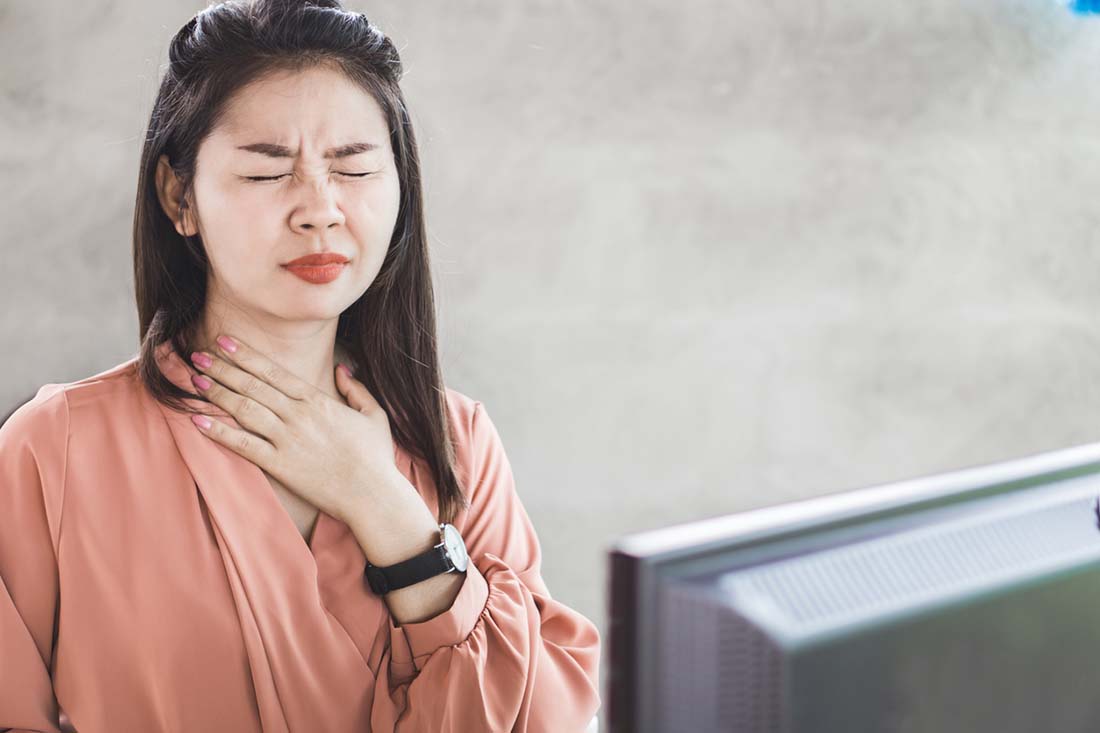 Asian woman suffering from acid reflux or heartburn