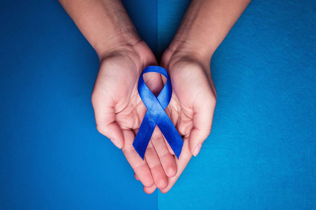 blue ribbon in support of trafficking and sexual slavery. Blue ribbon on female hands on a blue background